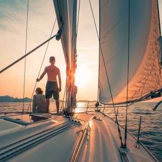 Young,Couple,Sailing,On,The,Boat,At,Sunset